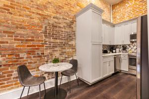 une cuisine avec un mur en briques, une table et des chaises dans l'établissement The Sazerac, à La Nouvelle-Orléans