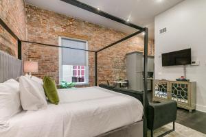 1 dormitorio con cama y pared de ladrillo en The Sazerac, en Nueva Orleans