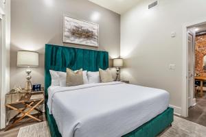 a bedroom with a large bed with a green headboard at The French 75 in New Orleans