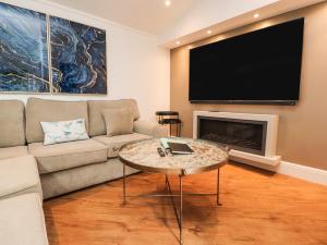 a living room with a couch and a flat screen tv at Retreat By The Bowers in Preston