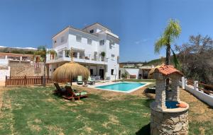 a villa with a swimming pool and a house at Los Nísperos in Algarrobo-Costa