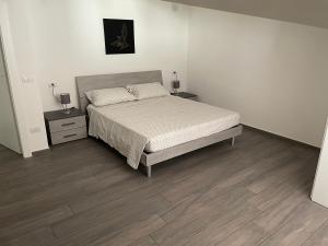 um quarto com uma cama e duas mesas de cabeceira em A&O Apartment em San Leucio
