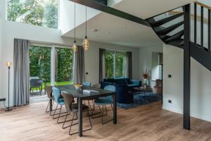 a dining room and living room with a table and chairs at Vakantiewoning De Bleekersvallei in De Koog