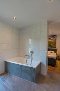 a bath tub in a room with a bedroom at Vakantiewoning De Bleekersvallei in De Koog