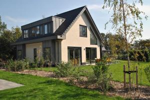a house with a black roof at Vakantiewoning De Bleekersvallei in De Koog