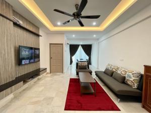 a living room with a couch and a ceiling fan at Century Suria Aparment Langkawi by Zervin in Kuah