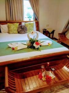 a bed with two towels and flowers on it at Lucy's guesthouse in La Digue