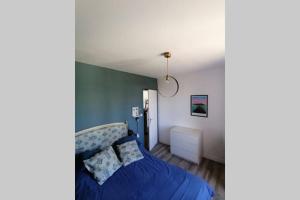 ein Schlafzimmer mit einem blauen Bett in einem Zimmer in der Unterkunft Jolie maison de vacances Noirmoutrine in Noirmoutier-en-l'lle