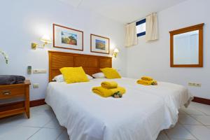 a bedroom with a large white bed with yellow pillows at Brisa Marina in Puerto Calero +18 photos