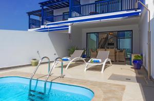 a house with a swimming pool and a patio at Brisa Marina in Puerto Calero