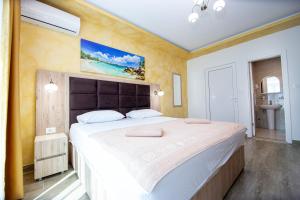 a bedroom with a large bed and a bathroom at Apartment Sofija in Budva
