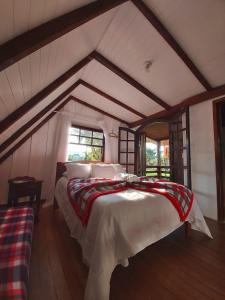 a bedroom with a large bed in a attic at Pousada e Restaurante Dona Siroba in Morretes