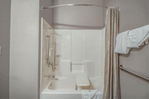 a bathroom with a shower and a white tub at Motel 6 Humble, TX - Houston International Airport in Humble