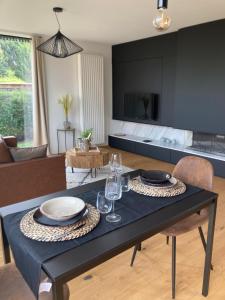 una sala de estar con una mesa con platos y copas de vino en Le 39 Espace Cocoon, en Namur