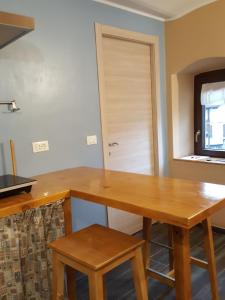 eine Küche mit einem Holztisch und 2 Hockern in der Unterkunft La terrazza in Giaveno
