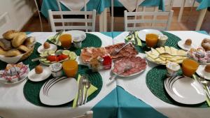 a table topped with plates of food and orange juice at Hotel Soazza in Soazza