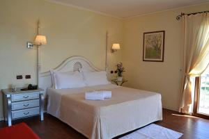 a bedroom with a large white bed and a window at Hotel Sa Contonera in Àrbatax