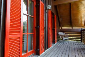 un porche de madera con puertas rojas y un banco en Villa Toni, en Bled