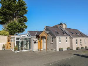 a house with a greenhouse on the side of it at Hazel Bank Cottage in Amlwch