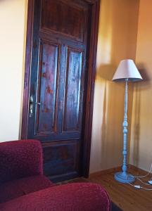 a room with a door and a lamp and a chair at Lithia s Stonehouse. Το πέτρινο στη Λιθιά - Καστοριά in Lithiá