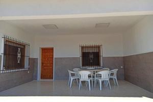 Zimmer mit einem Tisch, Stühlen und einer roten Tür in der Unterkunft Villa rústica privada con gran chalet y piscina in Elche