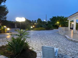 un patio de piedra con 2 sillas en un patio por la noche en Villa Eugenia in Campomarino di Maruggio, Puglia - casa vacanze, en Campomarino