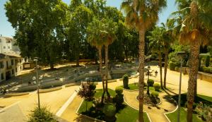 un parque con palmeras y una fuente en Alojamiento Turístico Fuente del Rey, en Priego de Córdoba