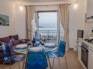 a living room with a table and chairs and a kitchen at Sanja Apartments Rivarela in Novigrad Istria