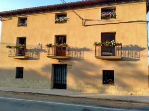 Apartamentos Rurales Rad Icarium في Radiquero: مبنى به علب الزهور على النوافذ