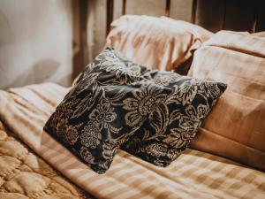 una almohada negra sobre una cama en Le Fantôme de Berthe logement-attraction insolite, en La-Roche-en-Ardenne