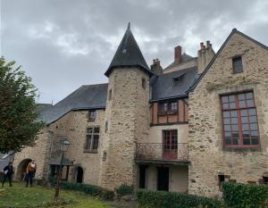 an old stone building with a black roof at Le logis du Vassal in Laval