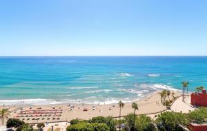 Una playa con un grupo de personas y el océano. en Apartamentos Benal Beach Group, en Benalmádena