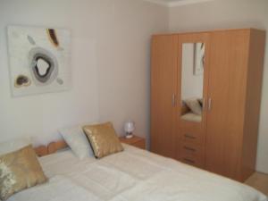 1 dormitorio con 1 cama y armario de madera en Apartment Silva, en Opatija
