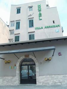 Un bâtiment blanc avec un panneau en haut dans l'établissement Hotel Villa Archirafi, à Palerme