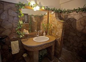 a stone bathroom with a sink and a mirror at Wood and Stone in Ioannina