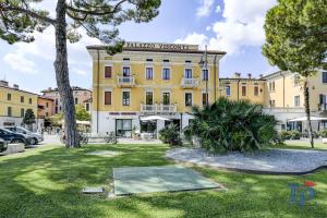 d'un grand bâtiment jaune avec un panneau. dans l'établissement DesenzanoLoft Palazzo Visconti Luxury Suite, à Desenzano del Garda