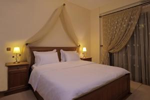 a bedroom with a large white bed with two lamps at Wood and Stone in Ioannina