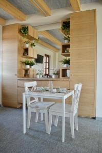 een witte eetkamer met een witte tafel en stoelen bij B&B La Luce Verde in Saluzzo
