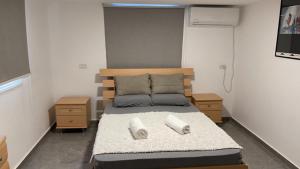 a bedroom with a bed with two pillows on it at 2לופית in Eilat