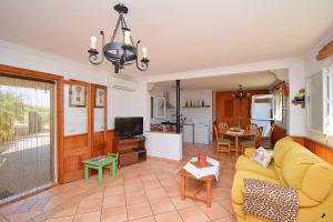 a living room with a yellow couch and a tv at 032 Finca Son Estrella ETV9306 by Mallorca Charme in Muro