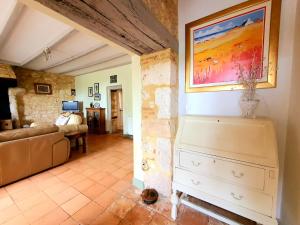 a living room with a couch and a painting on the wall at La Petite Auberge - Gîtes in Razac-dʼEymet