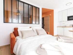 1 dormitorio con 1 cama blanca grande con almohadas en Apparts Seasons - Saint Étienne - La Terrasse, en Saint-Étienne