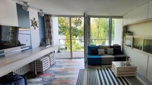salon z niebieską kanapą i dużym oknem w obiekcie Apartament Lazurowy 53 z tarasem i SPA w mieście Gródek Nad Dunajcem