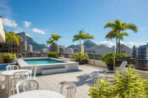 un patio con mesas y sillas y una piscina en Leblon Inn, bonito apartamento en Río de Janeiro