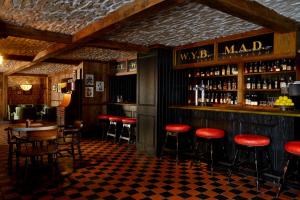 a bar with red stools in a restaurant at Rusacks St Andrews in St Andrews