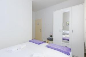 Una habitación blanca con una cama y un espejo. en Rooms Batina, en Dubrovnik