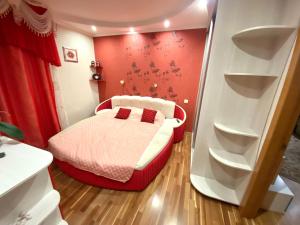 ポルタヴァにあるFamily Apartmentの赤い壁の小さなベッドルーム(ベッド1台付)