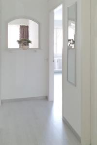 a white room with a door and a mirror at Bright and modern apartment in the heart of Altstätten in Altstätten