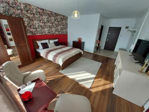 a bedroom with a bed and a living room at Anca's Style in Codlea