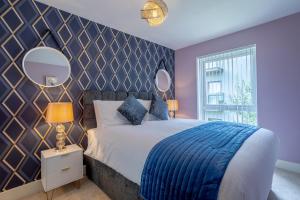 ein Schlafzimmer mit einem großen Bett und einem Spiegel in der Unterkunft LillyRose Apartments - Hemel Hempstead, Free Parking, Free Wi-Fi in Kings Langley